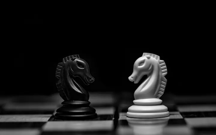 Dos piezas de ajedrez enfrentadas sobre el tablero