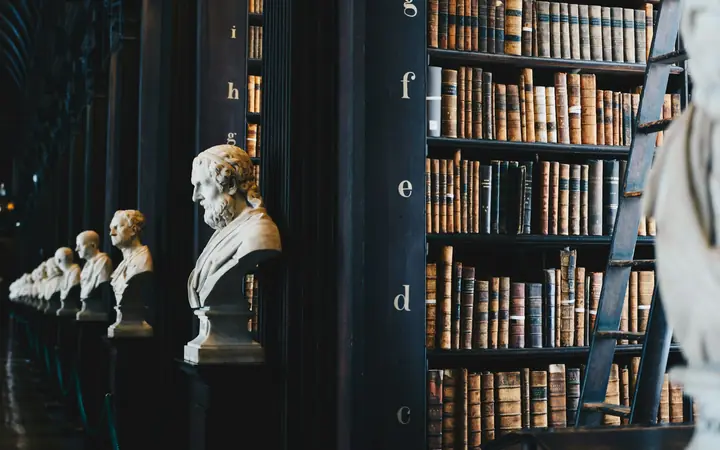 Biblioteca con libros antiguos y bustos