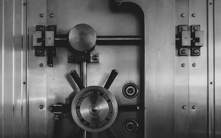Puerta metálica de una bóveda bancaria en blanco y negro