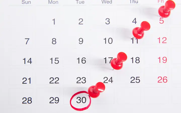 Calendario con alfileres rojos marcando fechas