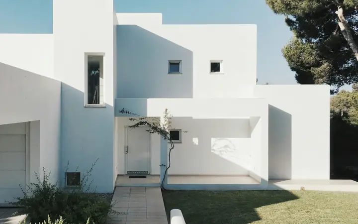 Casa blanca de estilo moderno con jardín