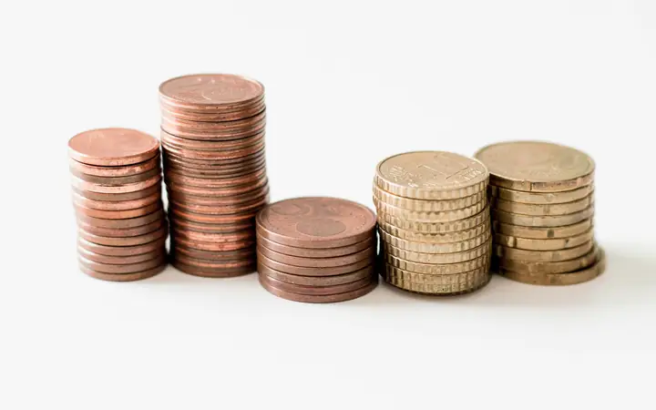 Pilas de monedas sobre una superficie blanca