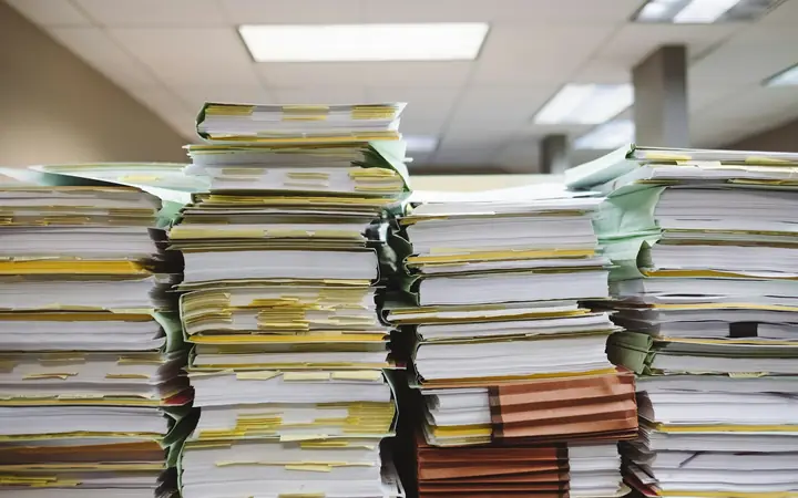 Pilas de expedientes y documentos en una oficina